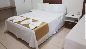 A hotel room with a large bed, a bedside table, a nightstand, and a wardrobe. - Hotel do Porto (Porto Franco)
