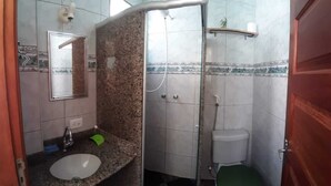 A bathroom with a granite countertop sink, a mirror, a shower enclosure, and a toilet. - Apartment 170m from Praia do Forte (Centro)