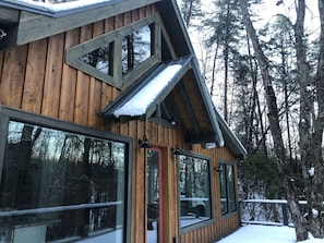 A wooden cabin with large windows and a sloped roof.