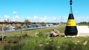 Escena costera con una boya que indica "PORT DE GOULÉE" y un puerto deportivo con barcos.