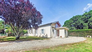 Una casa de un piso con entrada de grava y césped cuidado.