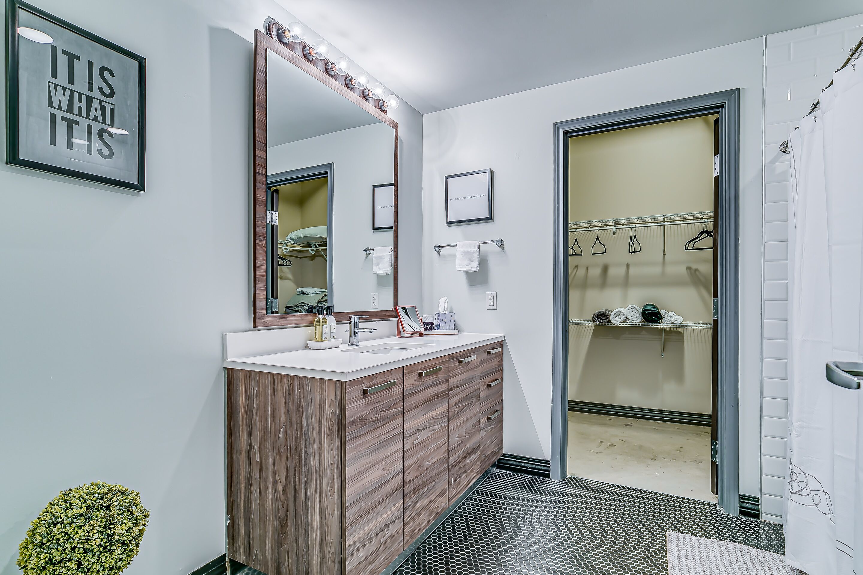 Un bagno moderno con lavabo, specchio e cabina armadio.