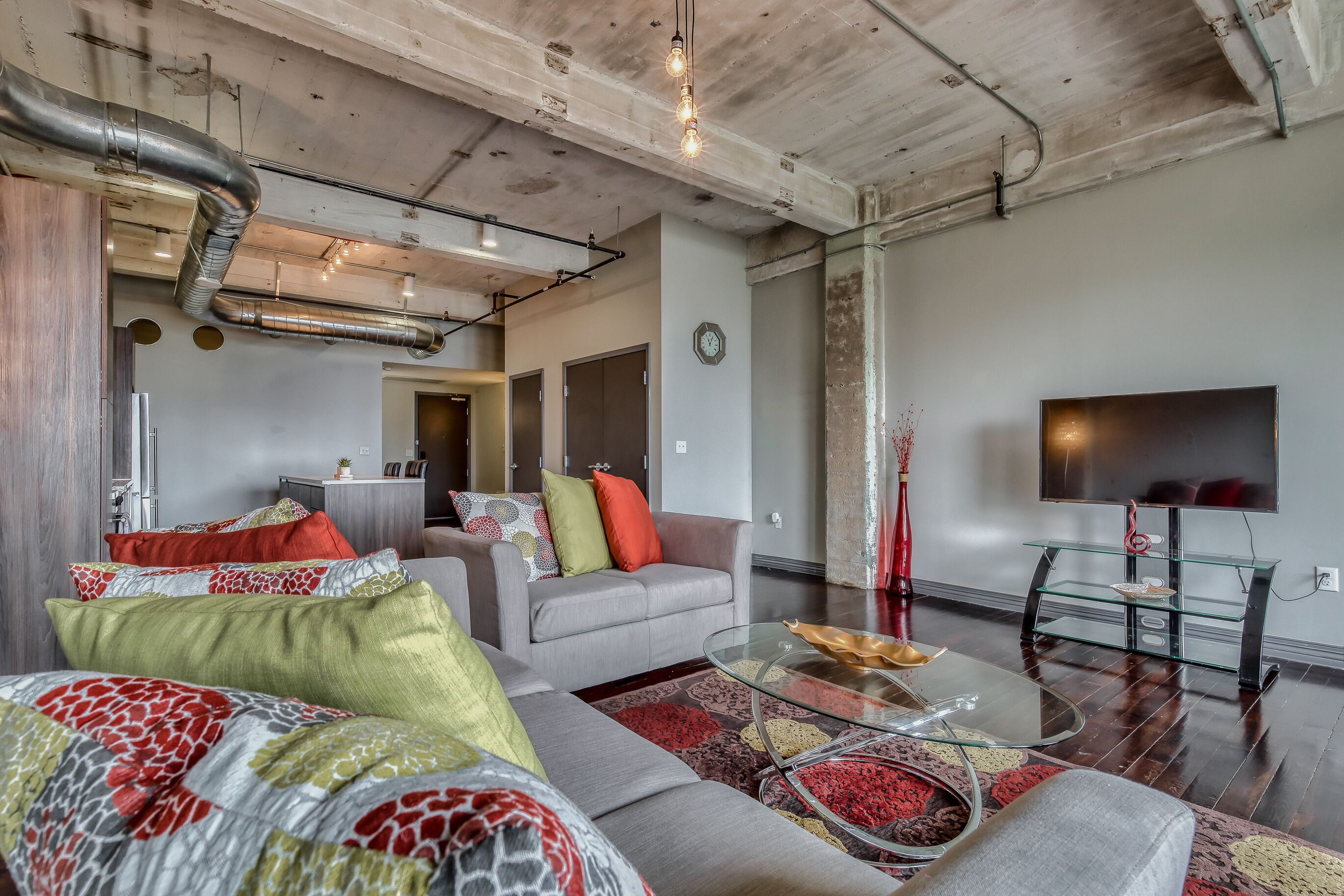 Een moderne woonkamer met een bank, salontafel en een flatscreen televisie.