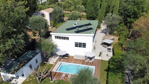 Ein modernes Haus mit Swimmingpool, Terrasse und Garten.