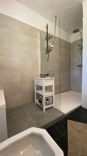 Tina con regadera, secadora de cabello, bidet, toallas 