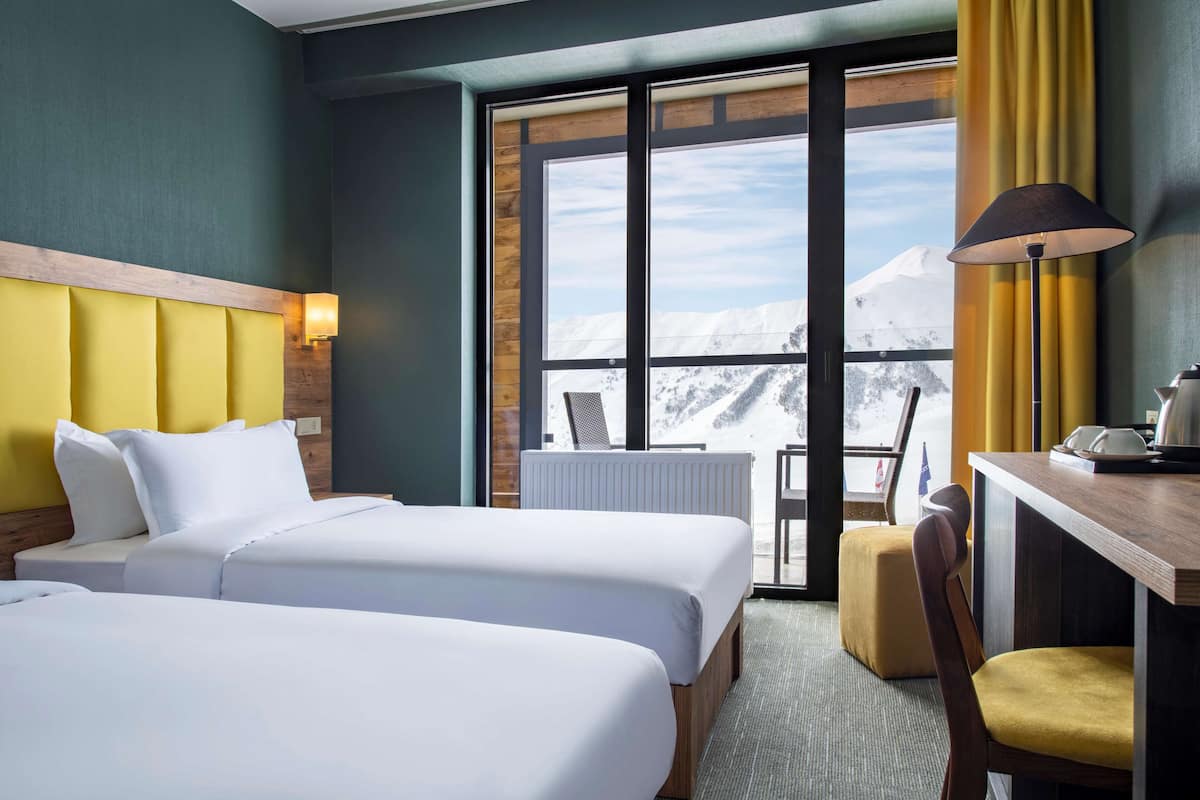 Quarto superior, 2 camas de solteiro, sacada, vista para a montanha | Escrivaninha, quartos à prova de som, acesso grátis à internet com fio