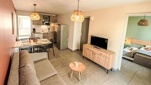Un appartement moderne comprenant un salon, un coin repas, une kitchenette et une chambre.