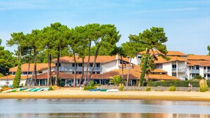 Un hotel sul lungomare con diversi edifici, una spiaggia sabbiosa e barche.
