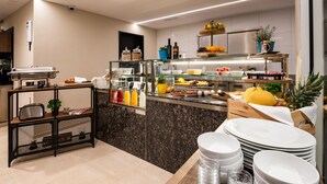 Een moderne keuken met een buffetopstelling, met verschillende soorten fruit, groenten en drankjes.