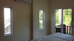 A bedroom with a bed, an air conditioning unit, and two windows. - Ban Sabai 2 - Koh Phangan (Koh Phangan)