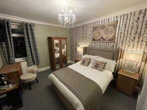 A bedroom with a large bed, a wardrobe, a desk, and a chair. - McGraths Blackpool (Blackpool)