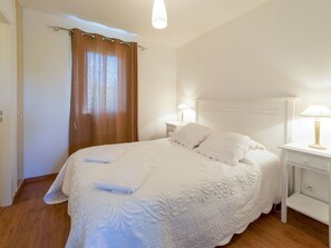 Cozy retreat with a neatly made bed, nightstand, and dresser, perfect for a restful stay.