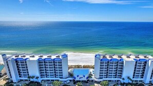 A beachfront hotel with multiple balconies, a pool, and a view of the ocean. - Direct Beachfront • Unobstructed Gulf Views • Low-Density Luxury at Aquavista (Panama City Beach)