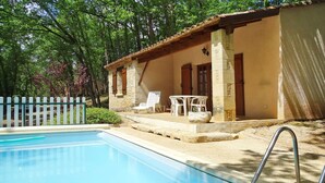 A swimming pool with a sunlit patio area, stone steps, and white outdoor furniture. - Beautiful private villa for 4 people with private pool, WIFI, TV, terrace and pets allowed (Blanquefort-sur-briolance)