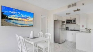 A modern kitchen with white cabinets, a stainless steel refrigerator, and a microwave. - CLOSE TO UNIVERSAL and International drive, 2 bedroom king suite with parking (Orlando)