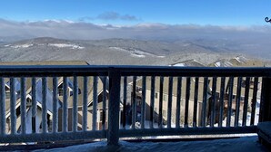 Un balcone con vista su montagne innevate e cielo sereno.