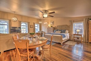 A cozy bedroom with a bed, bedside table, and a large window. - Chic Main Street Retreat < 7 Mi to KY Horse Park! (Georgetown)