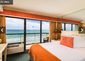 A hotel room with a large bed, a desk, a chair, and a view of the ocean. - Westgate Myrtle Beach waterfront (Myrtle Beach)