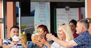 A group of people toasting with drinks in front of a restaurant. - Westgate Myrtle Beach waterfront (Myrtle Beach)