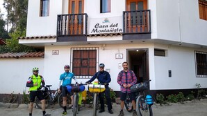 Un edificio con un letrero que dice "Casa del Montañista" y un balcón con barandilla.