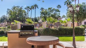 An outdoor patio area with a barbecue grill and a round table. - Ground Floor.Heated Pool! Hot Tub! Gas grill! 3 miles to Cardinal stad! 2 Kings! (Phoenix)