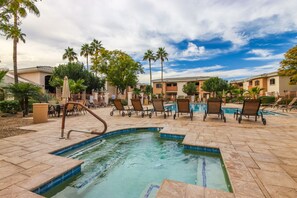 A pool area with lounge chairs and a small pool, surrounded by palm trees and buildings. - Ground Floor.Heated Pool! Hot Tub! Gas grill! 3 miles to Cardinal stad! 2 Kings! (Phoenix)