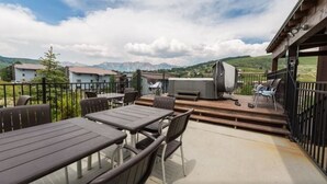 An outdoor patio with tables and chairs, a barbecue grill, and a view of mountains. - 207 Timbers Condominium (Crested Butte)