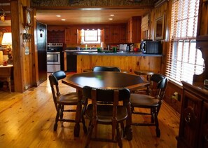 Enjoy meals in this kitchen with a central island, round dining table, and modern appliances.
