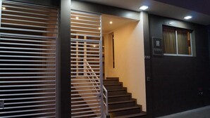 A staircase leading to a room with a window and a door with a sign. - Hotel Barrio 14 (Antofagasta)