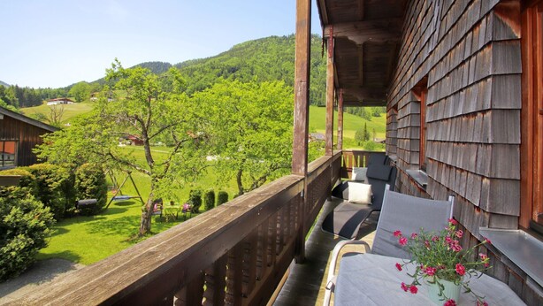 A wooden balcony with a view of a green landscape and a house in the background. - Apartment Westernberg 55sqm, terrace, kitchen, 1 bedroom, 1 bedsit. (Ruhpolding)