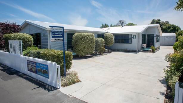 A two-story motel with a sign indicating availability of rooms and a parking area. - eMotel Napier (Napier)