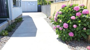 A pathway leading to a building with a sign that reads "Bike About Hours." - eMotel Napier (Napier)