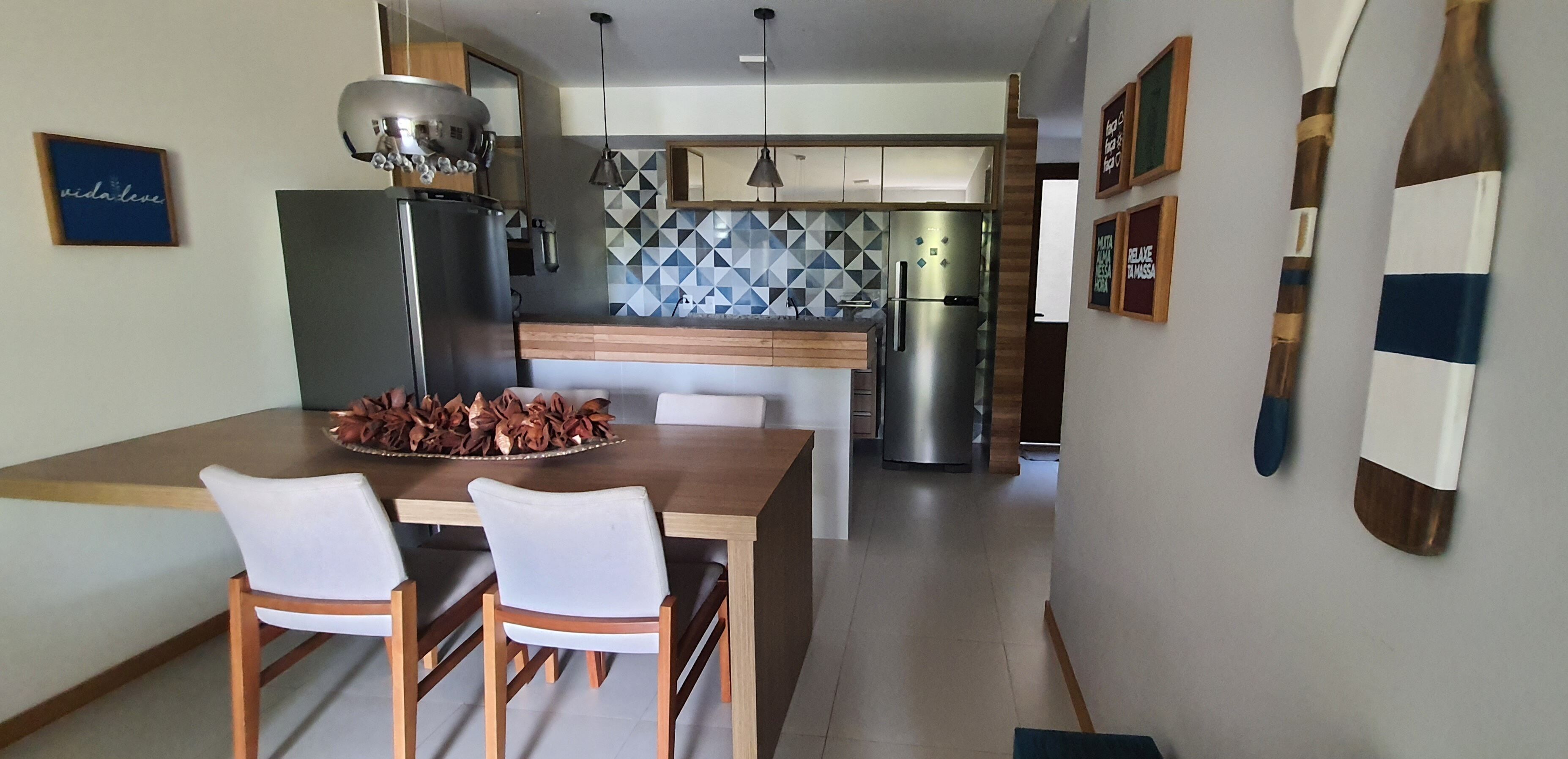 Een moderne keuken met een centraal eiland, roestvrijstalen apparatuur en een geometrisch patroon als achterwand.