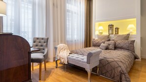 Une chambre à coucher avec un lit, une chaise, un bureau et une table de chevet.
