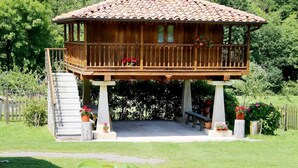 A wooden gazebo with a tiled roof, surrounded by a well-maintained lawn and potted plants. - House with Garden and Barbecue in Llanes - Molinin (Ardisana)