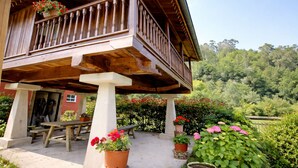 A wooden balcony with a railing, a table, and potted plants. - House with Garden and Barbecue in Llanes - Molinin (Ardisana)