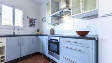 Een koelkast, een magnetron, een oven, kookgerei, borden en bestek