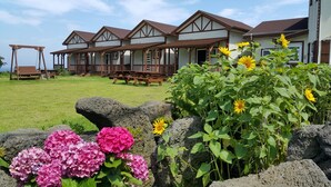 Um hotel com vários quartos, um gramado e um jardim de pedras com flores.
