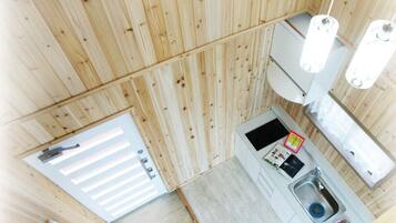 Une cuisine de taille réduite, dotée d’un évier, d’un petit plan de travail et d’un plafond en bois.