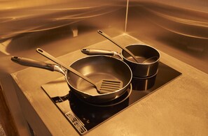 A kitchen with a stove, two frying pans, and a spatula. - Zen (Kyoto)
