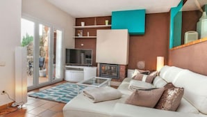A modern living room with a sofa, television, and a fireplace. - Berganti by Interhome (Tossa de Mar)