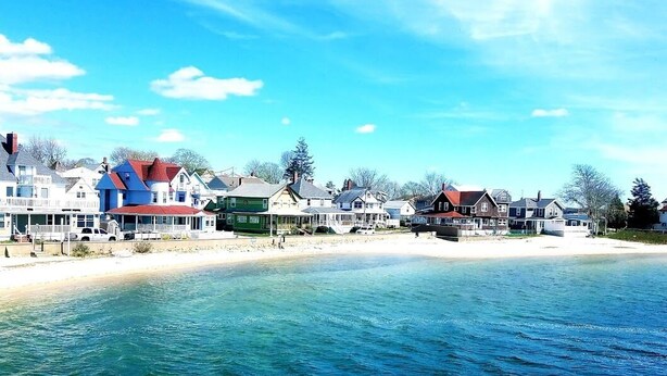 En kystby med huse langs stranden og havudsigt.