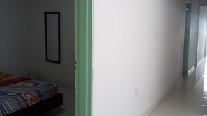 A hotel room with a bed, a green-framed doorway, and a tiled floor. - Casa Love (Guadalajara de Buga)