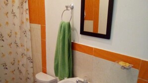 A bathroom with a toilet, sink, and shower curtain. - Casa Love (Guadalajara de Buga)