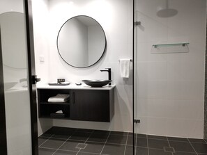 Een douche, designer toiletartikelen, een haardroger, handdoeken