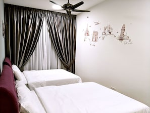 A hotel room with two beds, a ceiling fan, and a wall with a Europe-themed mural.