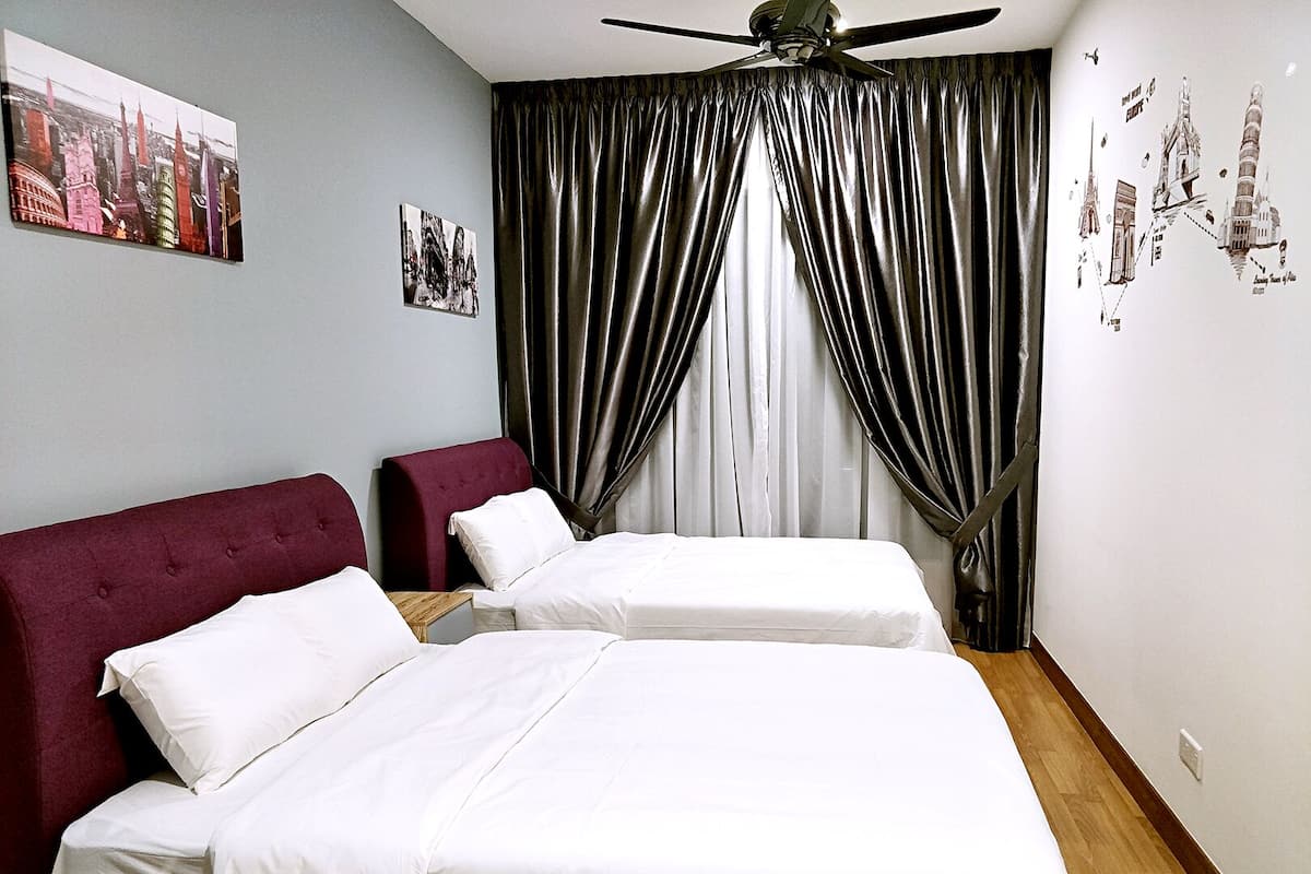 Quarto de hotel com duas camas, um ventilador de teto e uma pintura urbana na parede.