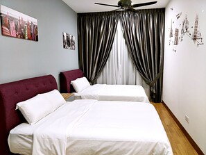 Ein Hotelzimmer mit zwei Betten, einem Deckenventilator und einer Stadtansicht als Wandbild.