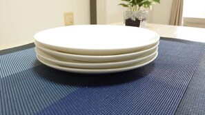 Una pila de platos blancos sobre un tapete azul con textura.