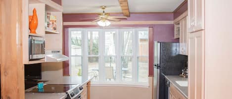 A kitchen with a microwave, stove, oven, and refrigerator.